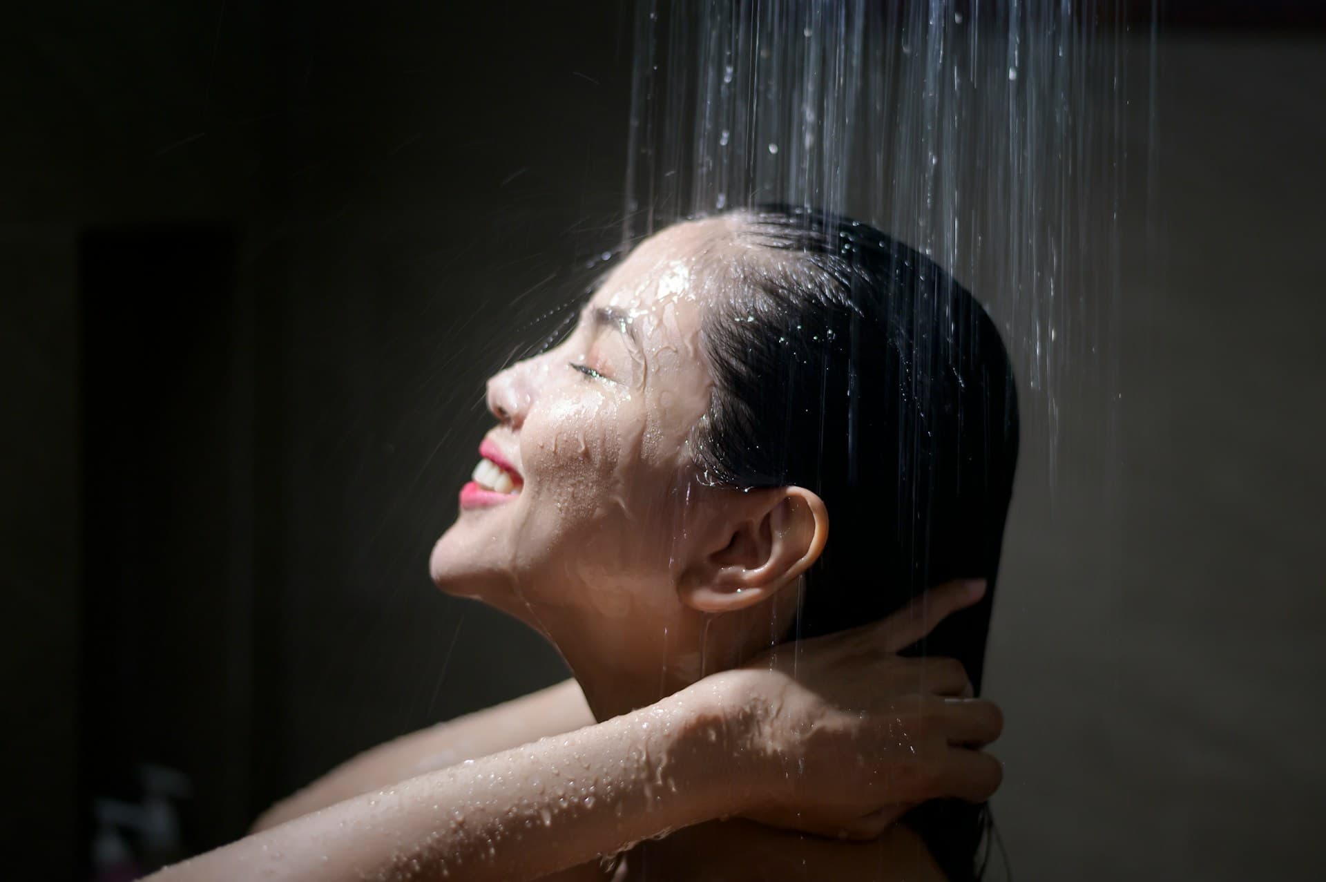 Young beautiful woman washing her hair in a bathroom at home
