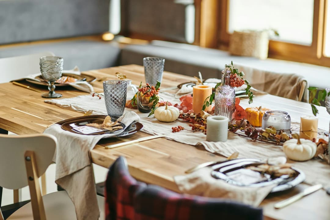 Close-up of beautiful autumn decoration from candles vegetables and branches on dining table